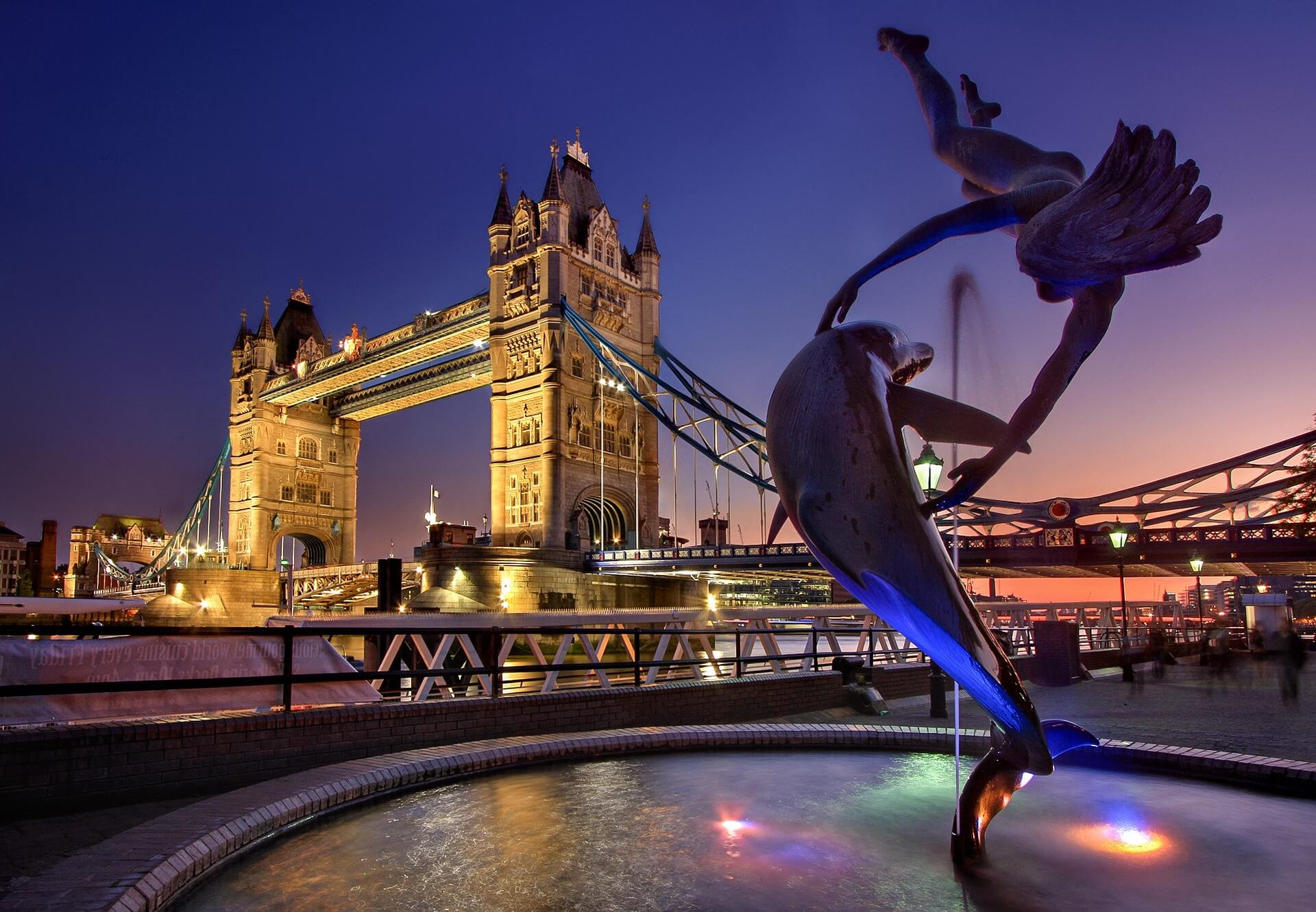 Tower Bridge at dusk, with the Girl with a Dolphin fountain in front.